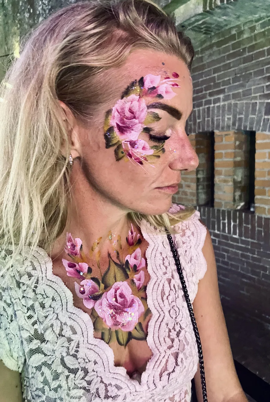 Vrouw met fijn geschilderde rozen op gezicht en decolleté
