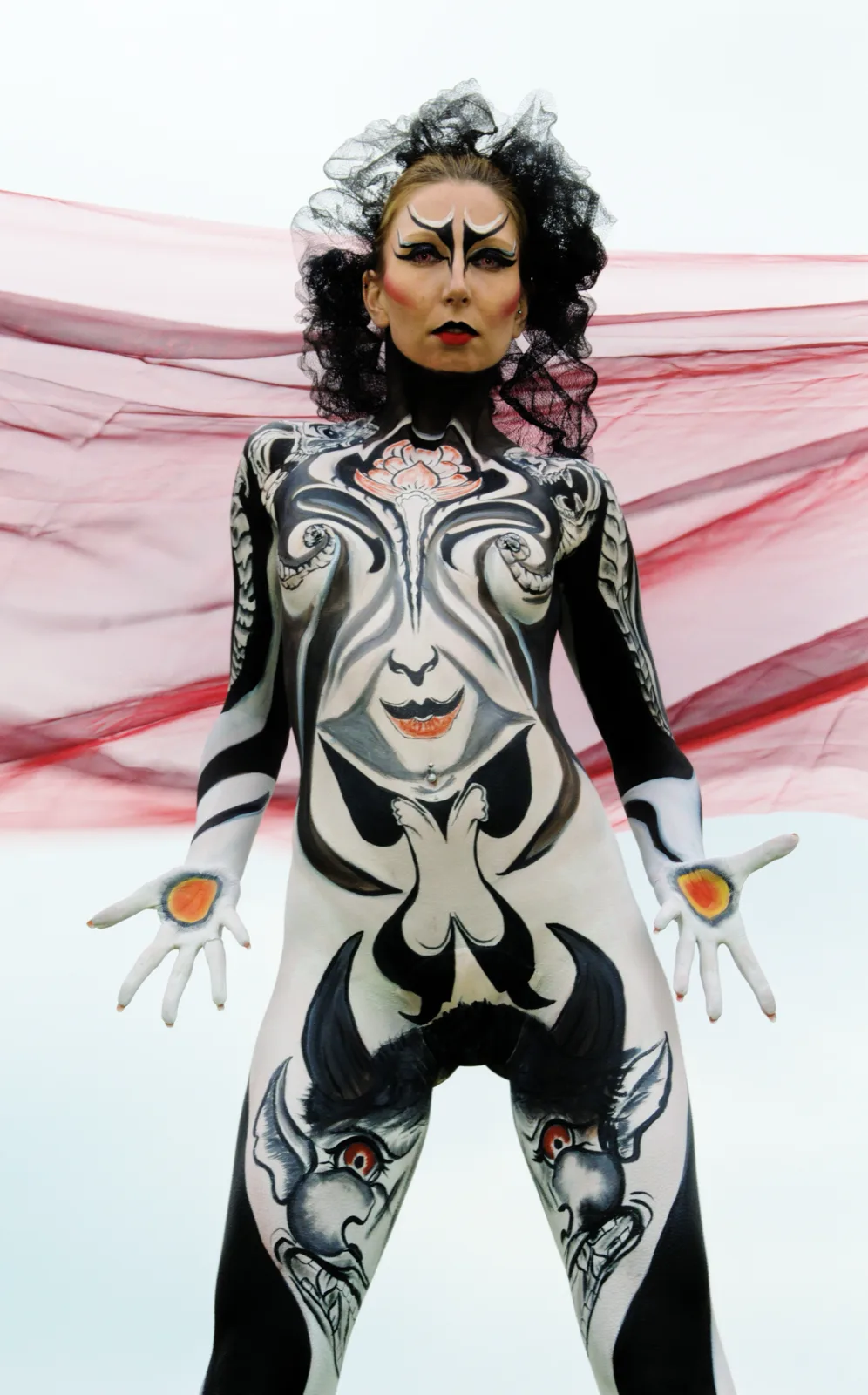 Zwart-wit tribale bodypaint tegen een rode doek