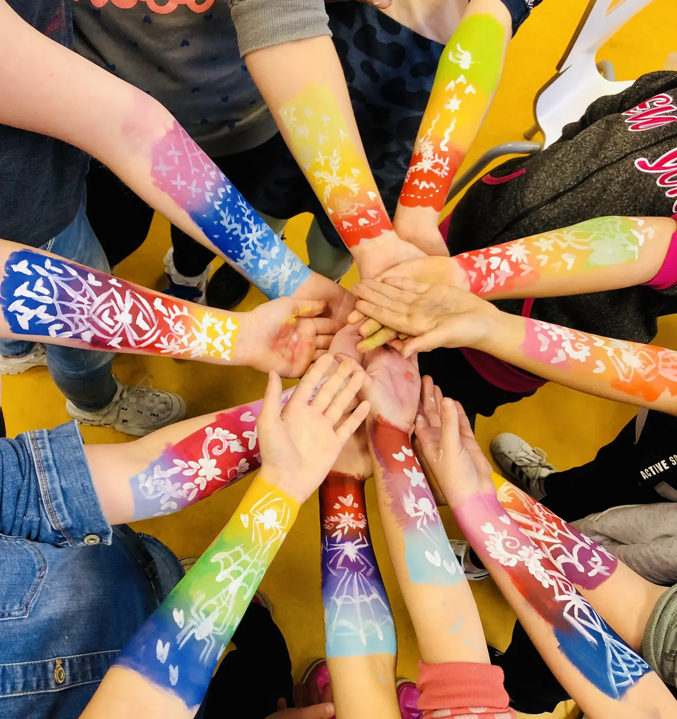 Deelnemers tonen hun beschilderde armen na een workshop